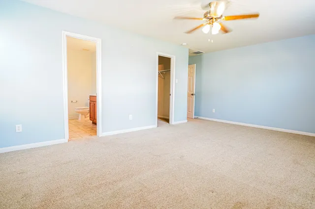 an empty room with a ceiling fan and a window