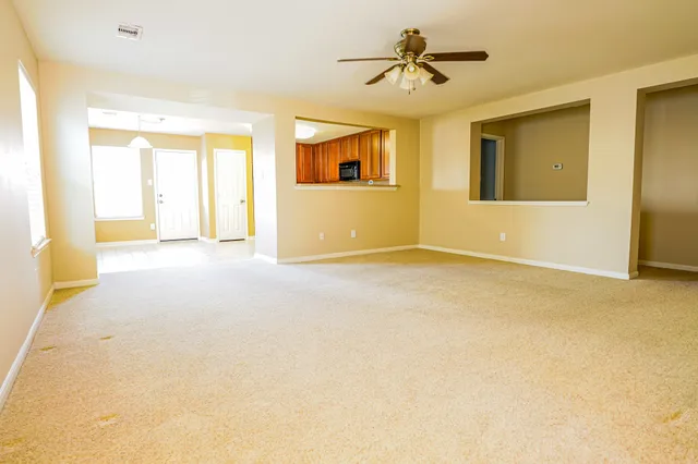 a view of a livingroom with a window and a ceiling fan