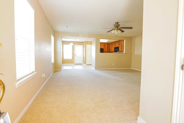 a view of a room with a windows and a ceiling fan