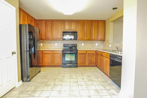 a kitchen with stainless steel appliances granite countertop a refrigerator sink and cabinets