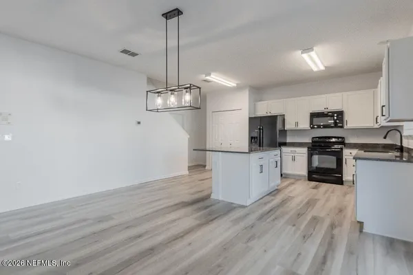 a view of a kitchen with microwave and cabinets