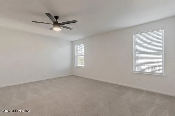 a view of a livingroom with a ceiling fan and window