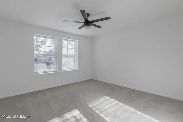 a view of a livingroom with a ceiling fan and window