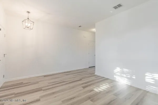 a view of a room with wooden floor and white walls