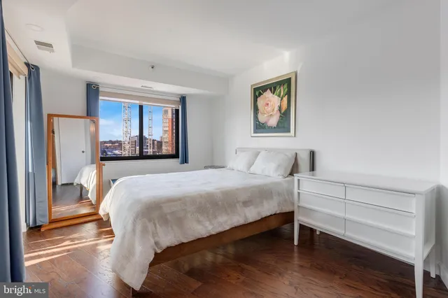 a bedroom with a bed and a large mirror in a bedroom