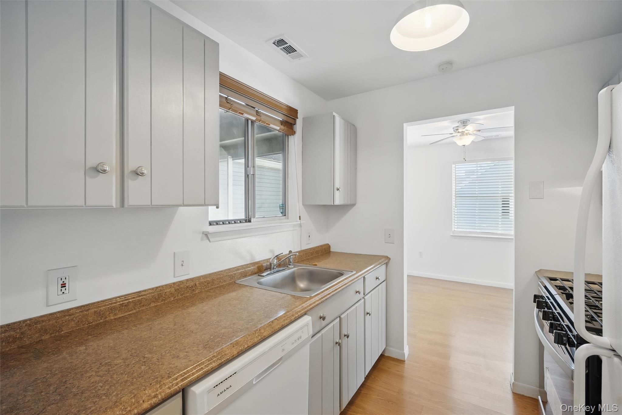201 Commons Way, Unit E Fishkill, NY 12524 - Photo 14 of 30 Kitchen with white appliances, light wood finished floors, and ceiling fan