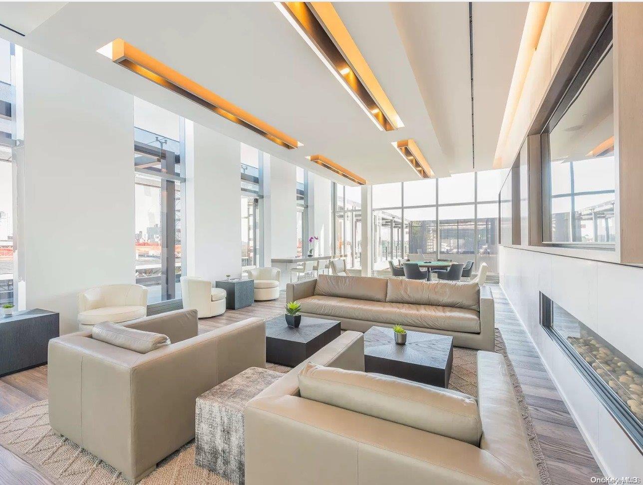 131-05 40 Road, Unit 11T Queens, NY 11354 - Photo 9 of 13 a living room with furniture and a large window