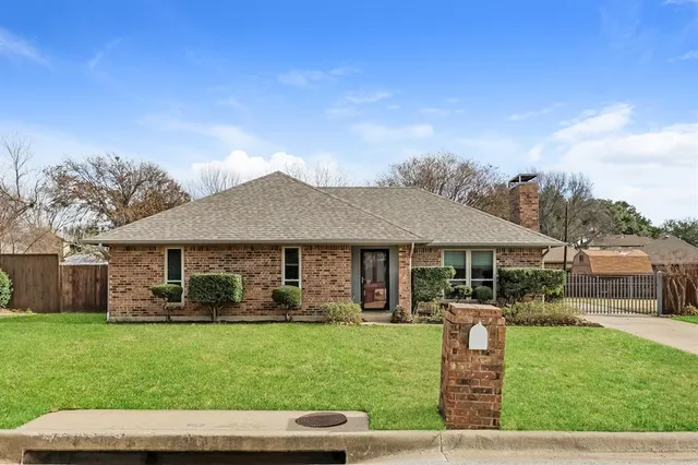 a front view of a house with a garden and yard