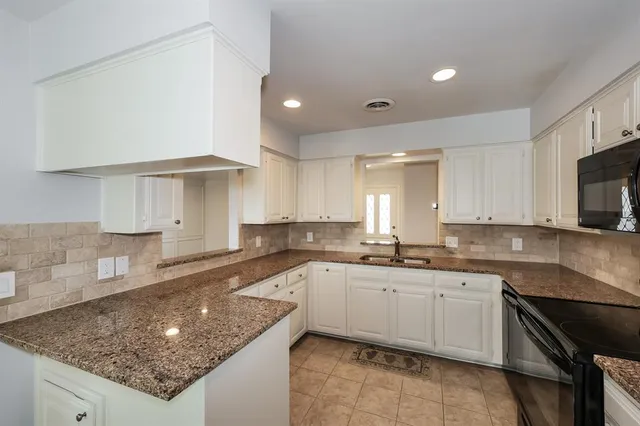 a kitchen with stainless steel appliances granite countertop a refrigerator a stove top oven a sink and dishwasher