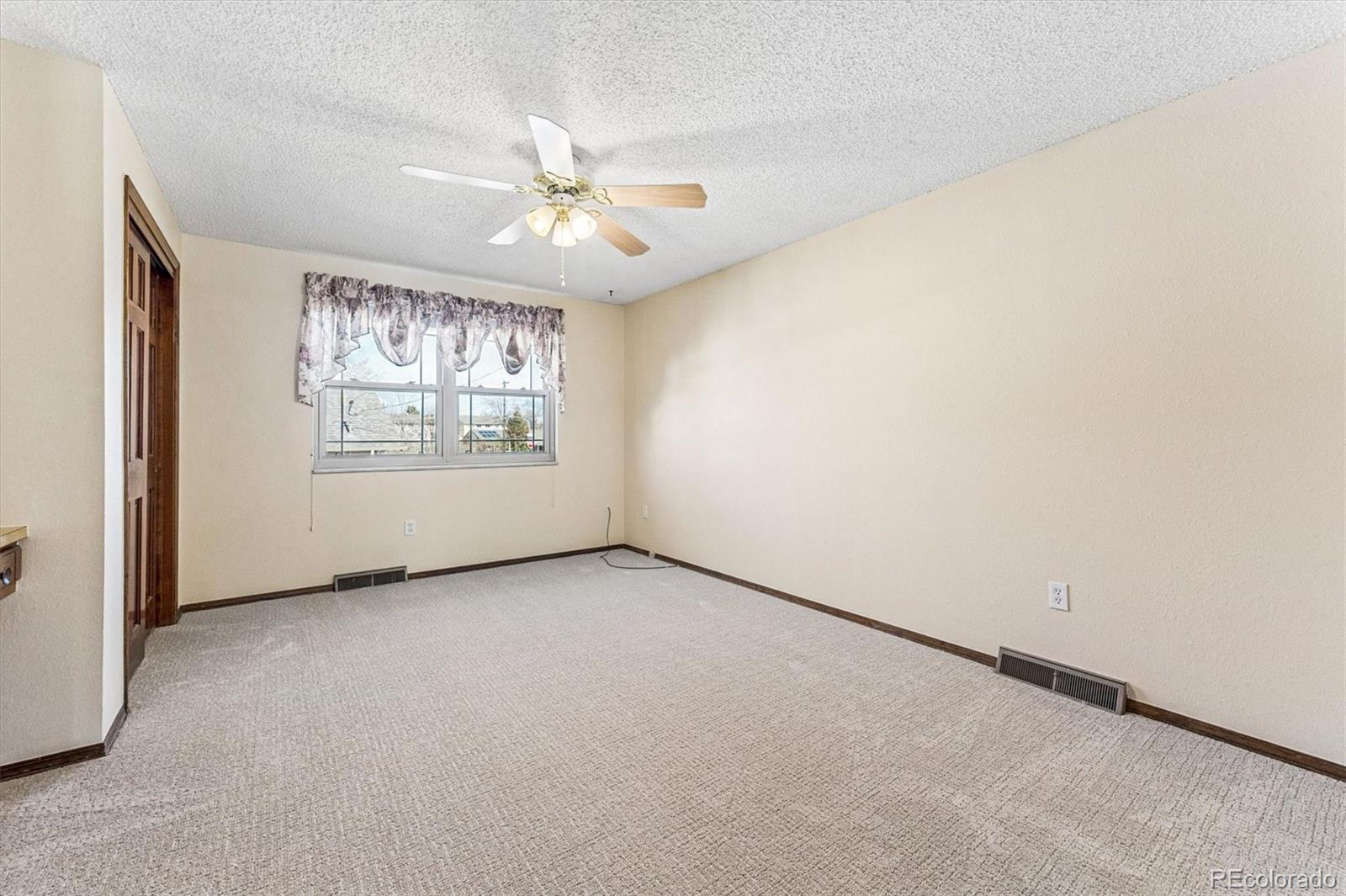 6505 West 34th Avenue Wheat Ridge, CO 80033 - Photo 12 of 28 an empty room with windows and fan