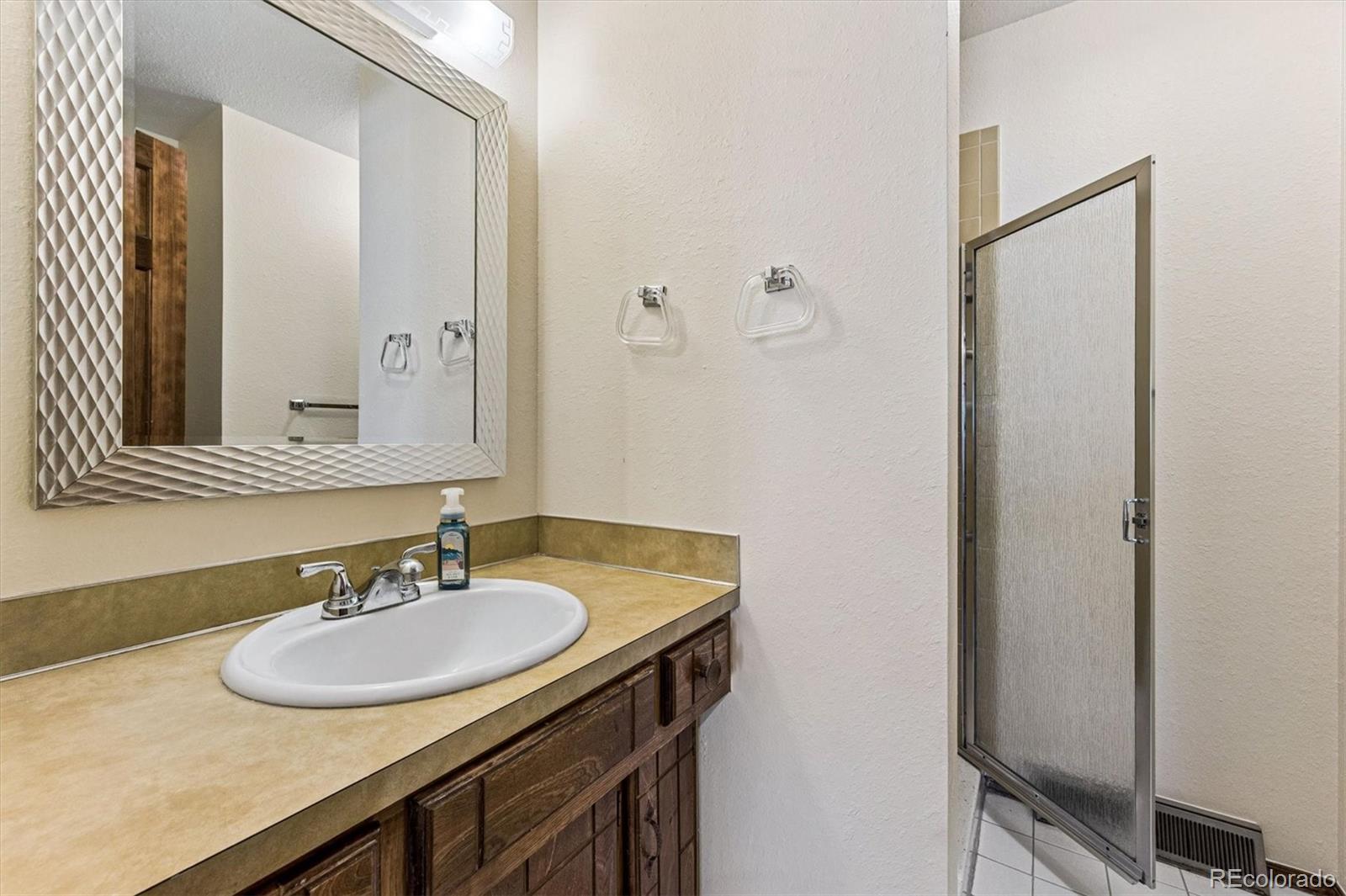 6505 West 34th Avenue Wheat Ridge, CO 80033 - Photo 14 of 28 a bathroom with a sink and a mirror