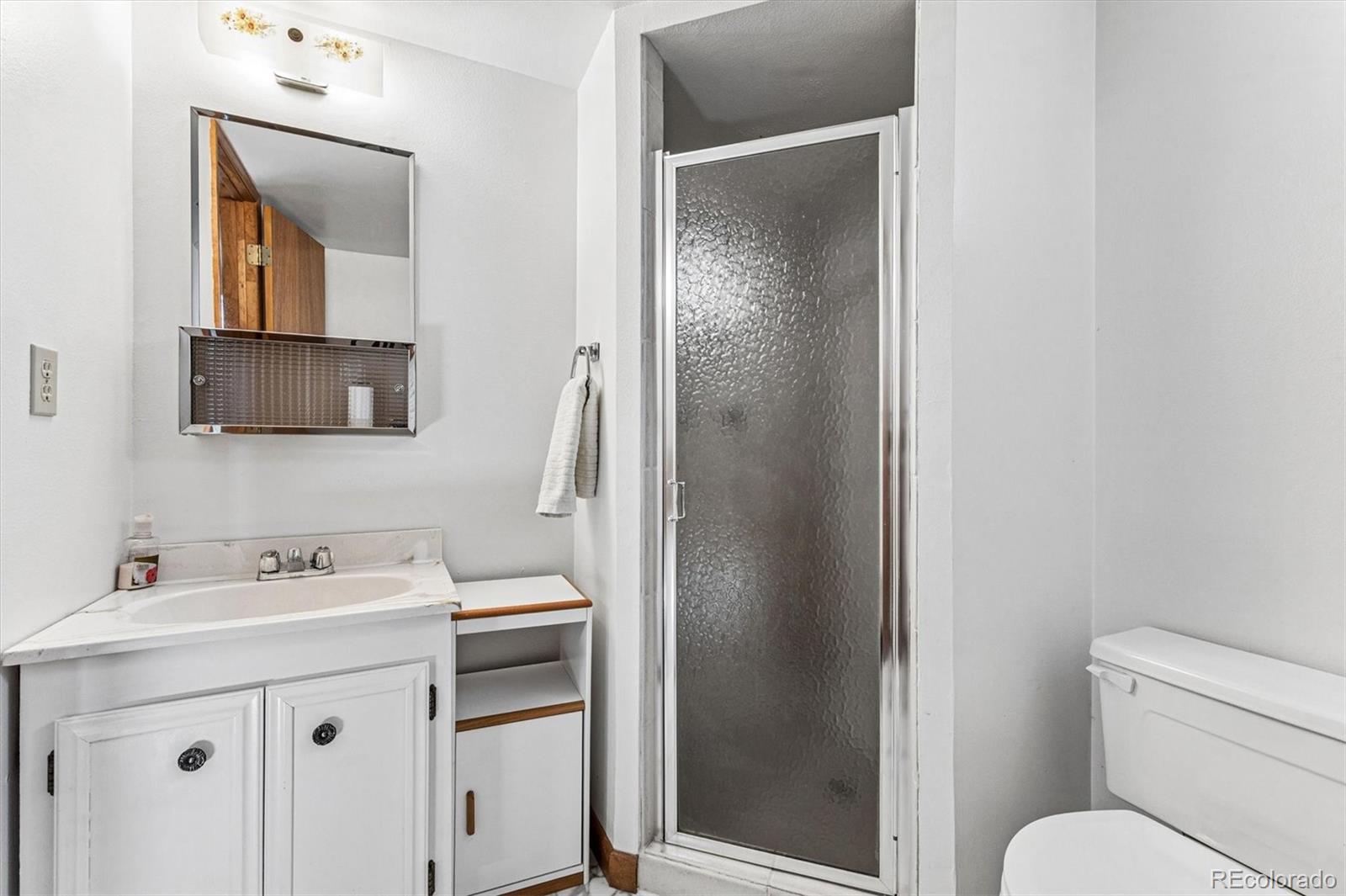 6505 West 34th Avenue Wheat Ridge, CO 80033 - Photo 19 of 28 a bathroom with a sink toilet and mirror