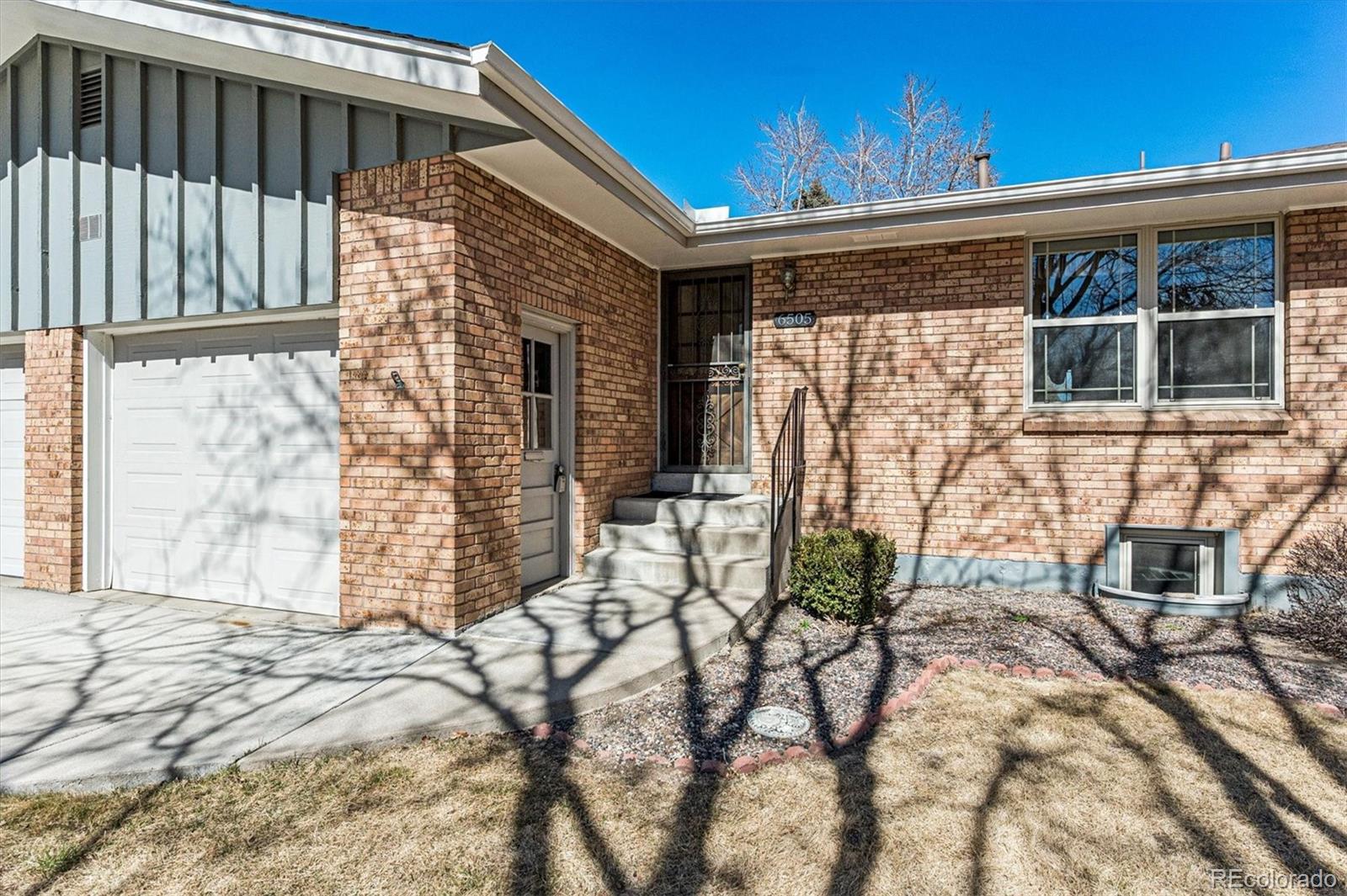 6505 West 34th Avenue Wheat Ridge, CO 80033 - Photo 3 of 28 a front view of a house with garden