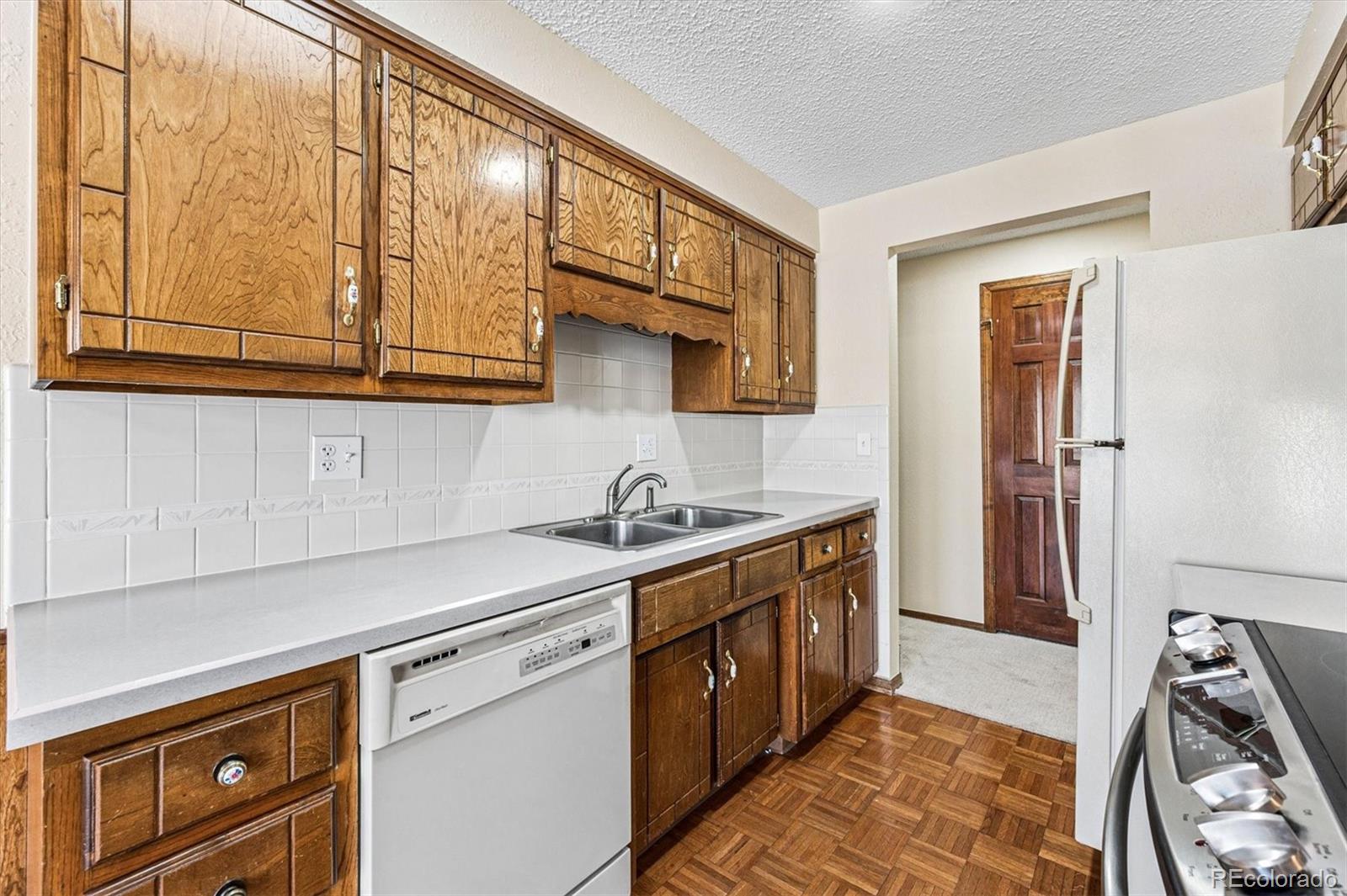 6505 West 34th Avenue Wheat Ridge, CO 80033 - Photo 9 of 28 a kitchen with stainless steel appliances granite countertop a sink stove and cabinets