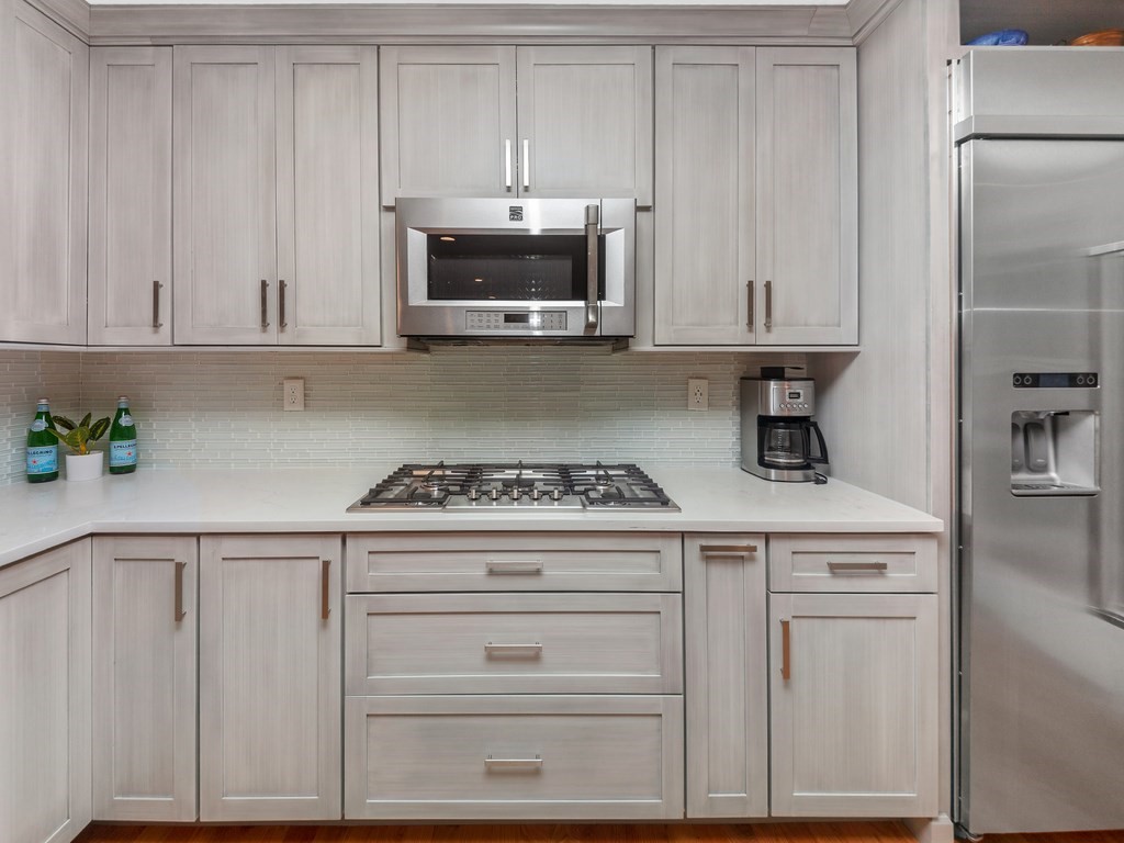 128 Olde Field Road Newton, MA 02459 - Photo 13 of 36 a kitchen with granite countertop white cabinets and stainless steel appliances