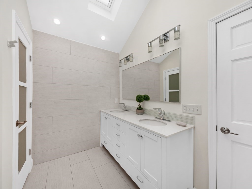 128 Olde Field Road Newton, MA 02459 - Photo 29 of 36 a spacious bathroom with a granite countertop sink and a mirror