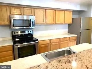 a kitchen with a stove a microwave and refrigerator
