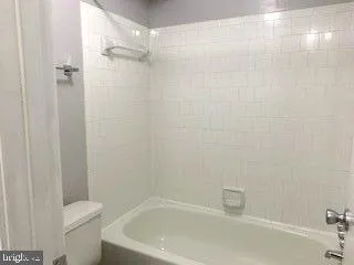 a white bath tub sitting next to a white toilet and a sink