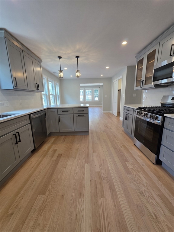 40 Lorna Road, Unit 2 Boston, MA 02126 - Photo 2 of 18 a large kitchen with wooden floors and stainless steel appliances