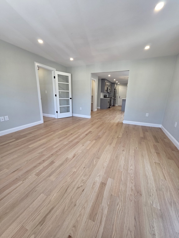 40 Lorna Road, Unit 2 Boston, MA 02126 - Photo 7 of 18 a view of empty room with wooden floor and stove