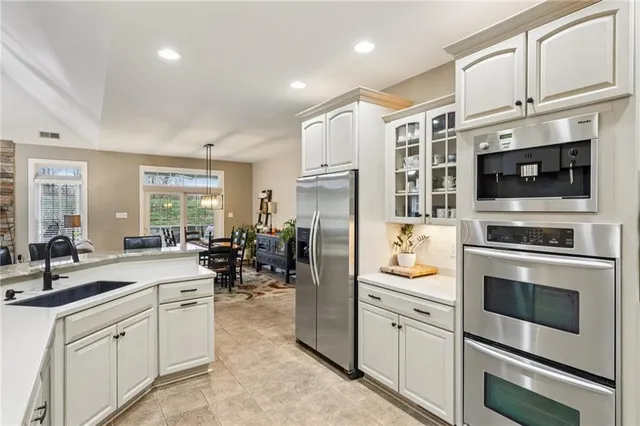 a kitchen with stainless steel appliances white cabinets and a refrigerator