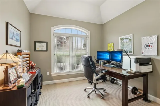 a view of a workspace with furniture and a window