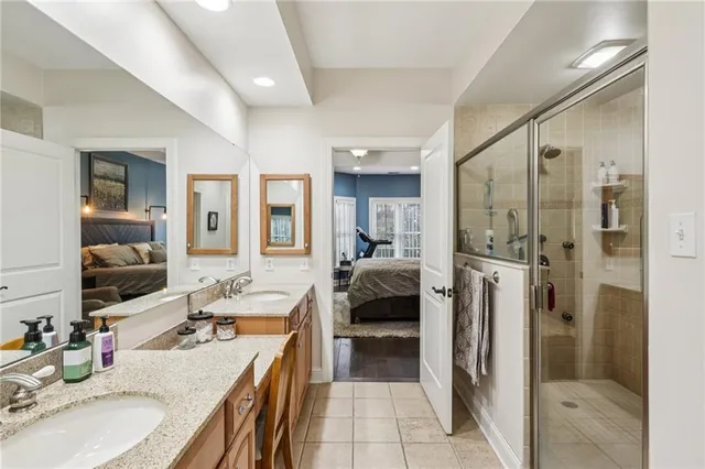 a en suite bathroom with a double vanity sink a large mirror and a shower