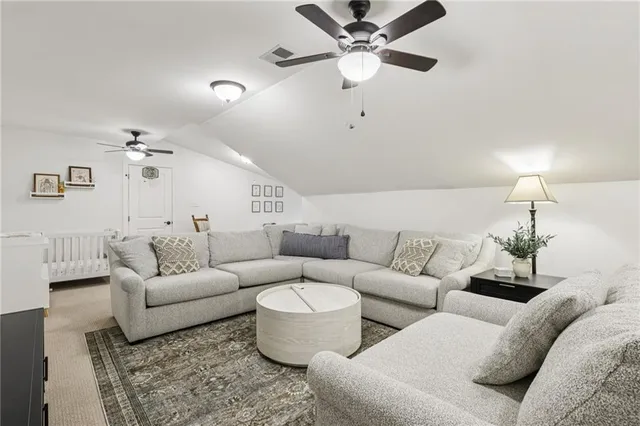 a living room with furniture and a ceiling fan