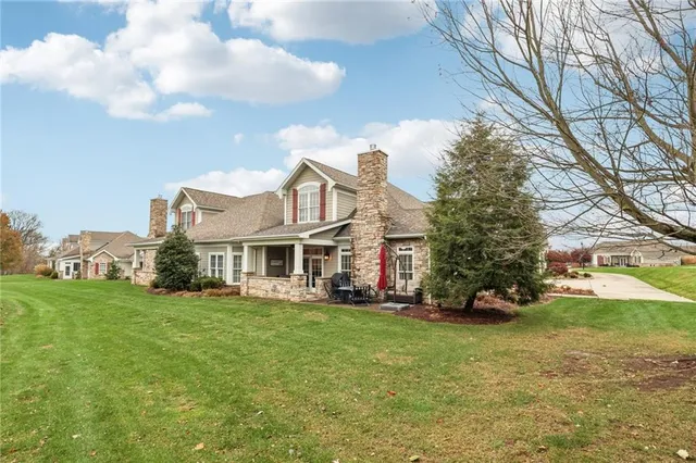 a front view of a house with a garden and trees