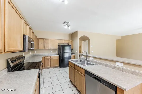 a large kitchen with a counter top space a sink a stove and refrigerator