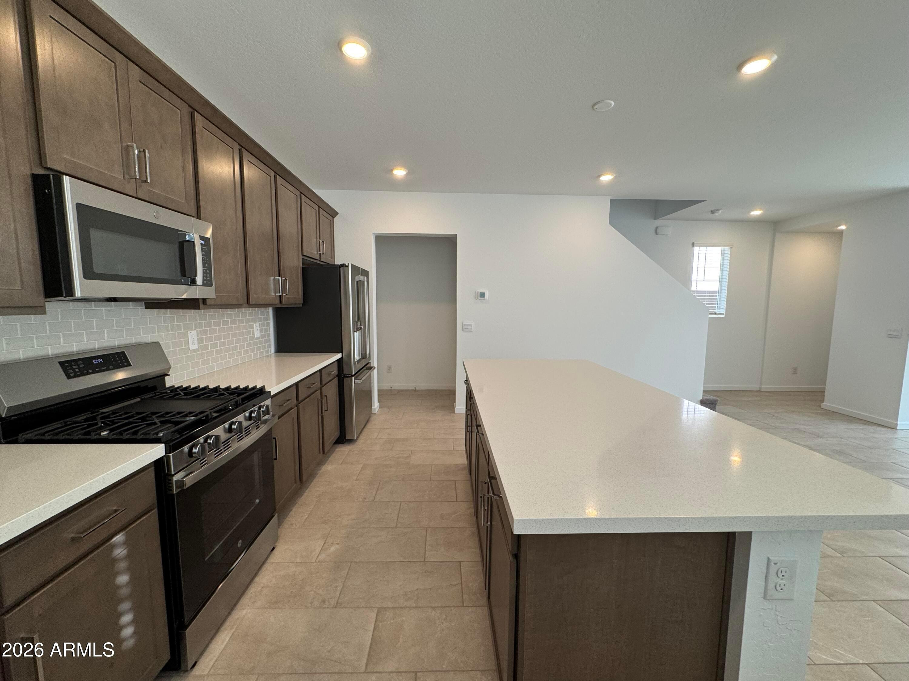 2438 West Rowel Road Phoenix, AZ 85085 - Photo 3 of 30 a kitchen with stainless steel appliances a refrigerator a stove a microwave a sink and cabinets