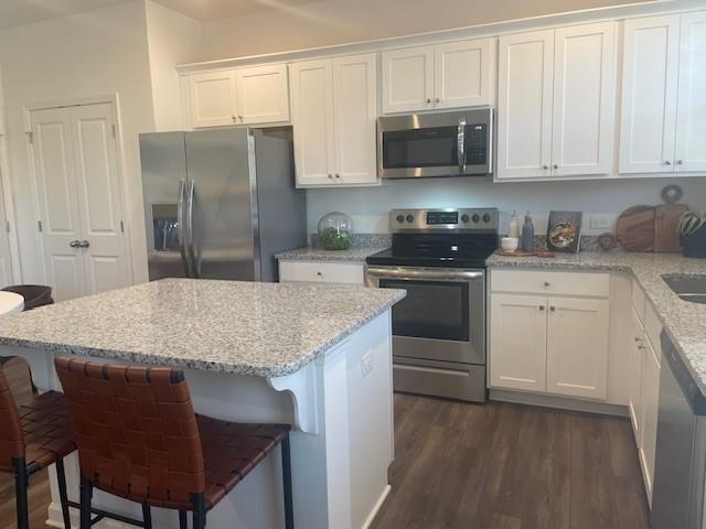 155 Star Court Pendergrass, GA 30567 - Photo 26 of 34 a kitchen with stainless steel appliances granite countertop a stove top oven a sink and white cabinets