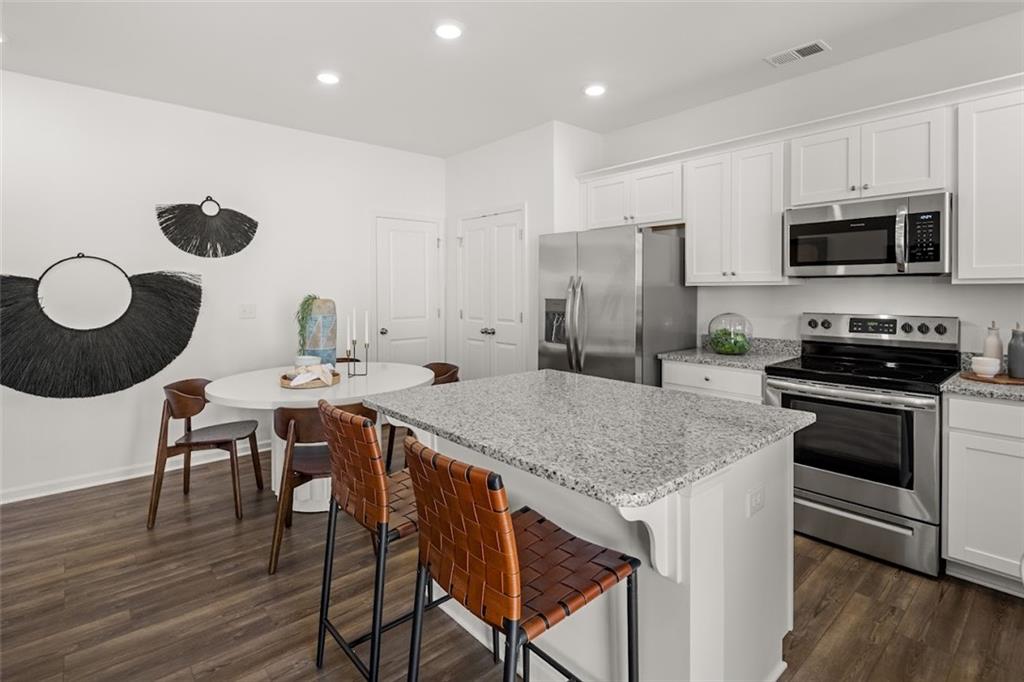155 Star Court Pendergrass, GA 30567 - Photo 4 of 34 a kitchen with a table chairs and a refrigerator