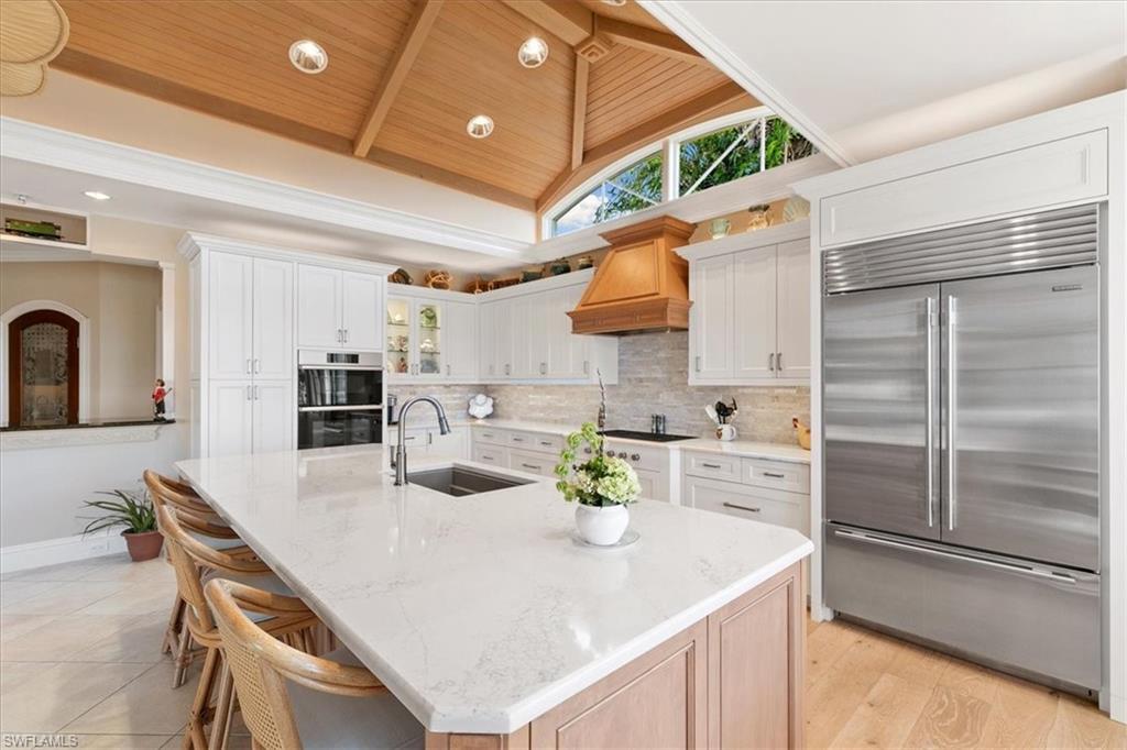 400 Springline Drive Naples, FL 34102 - Photo 12 of 32 a kitchen with a sink a stove and chairs