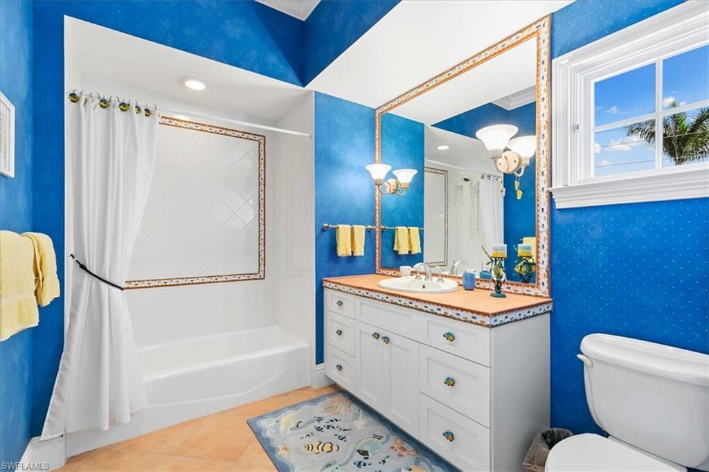 400 Springline Drive Naples, FL 34102 - Photo 27 of 32 a bathroom with a sink a toilet a mirror a vanity and shower