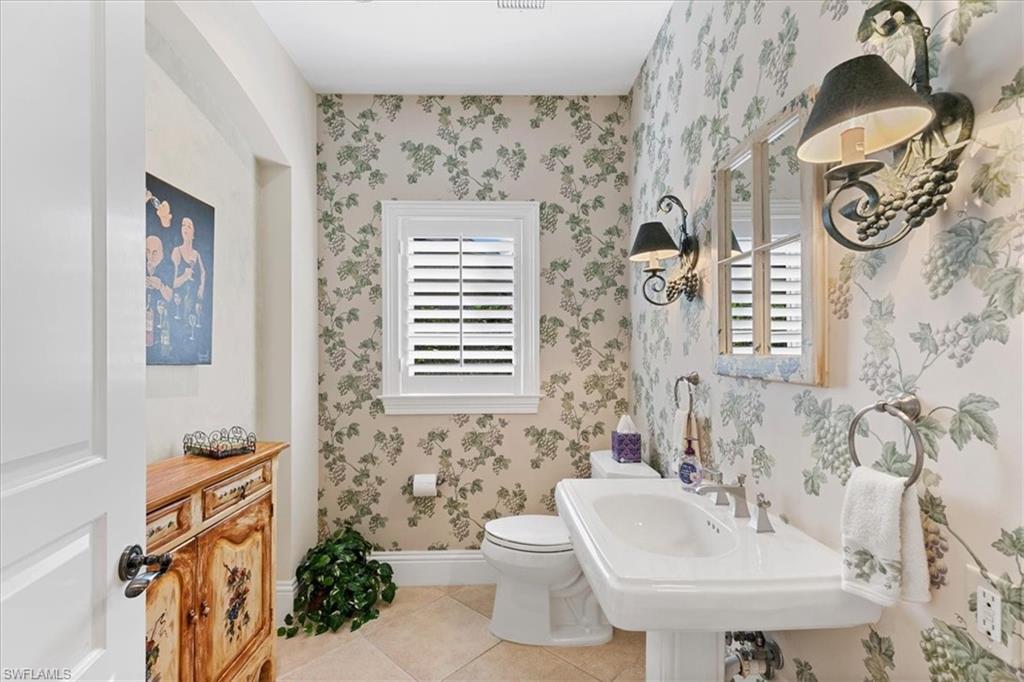 400 Springline Drive Naples, FL 34102 - Photo 31 of 32 a bathroom with a sink and mirror with toilet