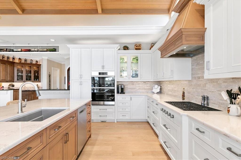 400 Springline Drive Naples, FL 34102 - Photo 10 of 32 a kitchen with granite countertop a sink and cabinets