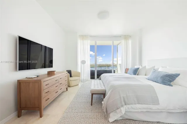 a bedroom with a large bed and a flat screen tv