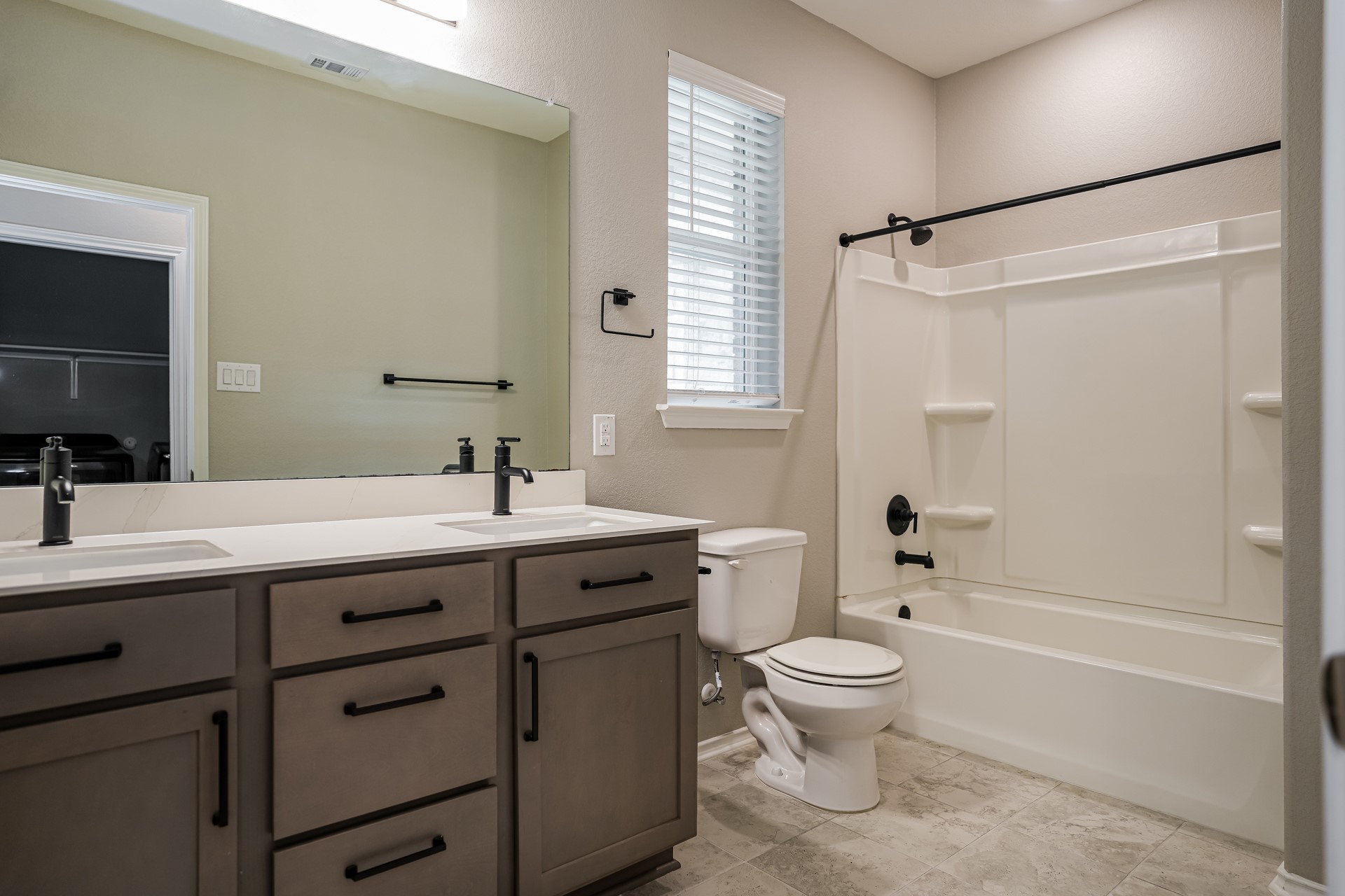 17313 Crazy Arm Road, Unit 233 Round Rock, TX 78664 - Photo 15 of 20 Guest bathroom with dual sinks, tub and shower combo, and tile flooring