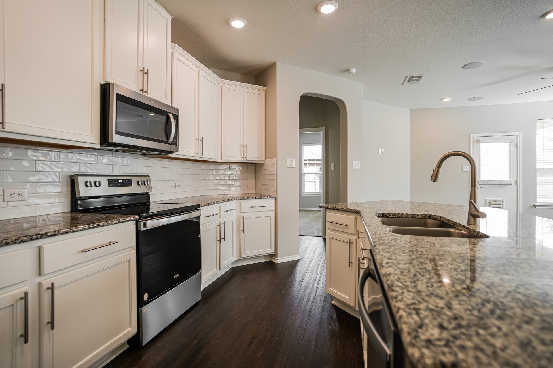17313 Crazy Arm Road, Unit 233 Round Rock, TX 78664 - Photo 4 of 20 Kitchen with large island, granite countertops and white cabinetry.
