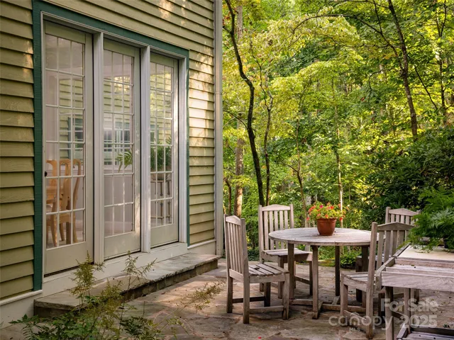 a view of a patio with table and chairs and floor to ceiling window