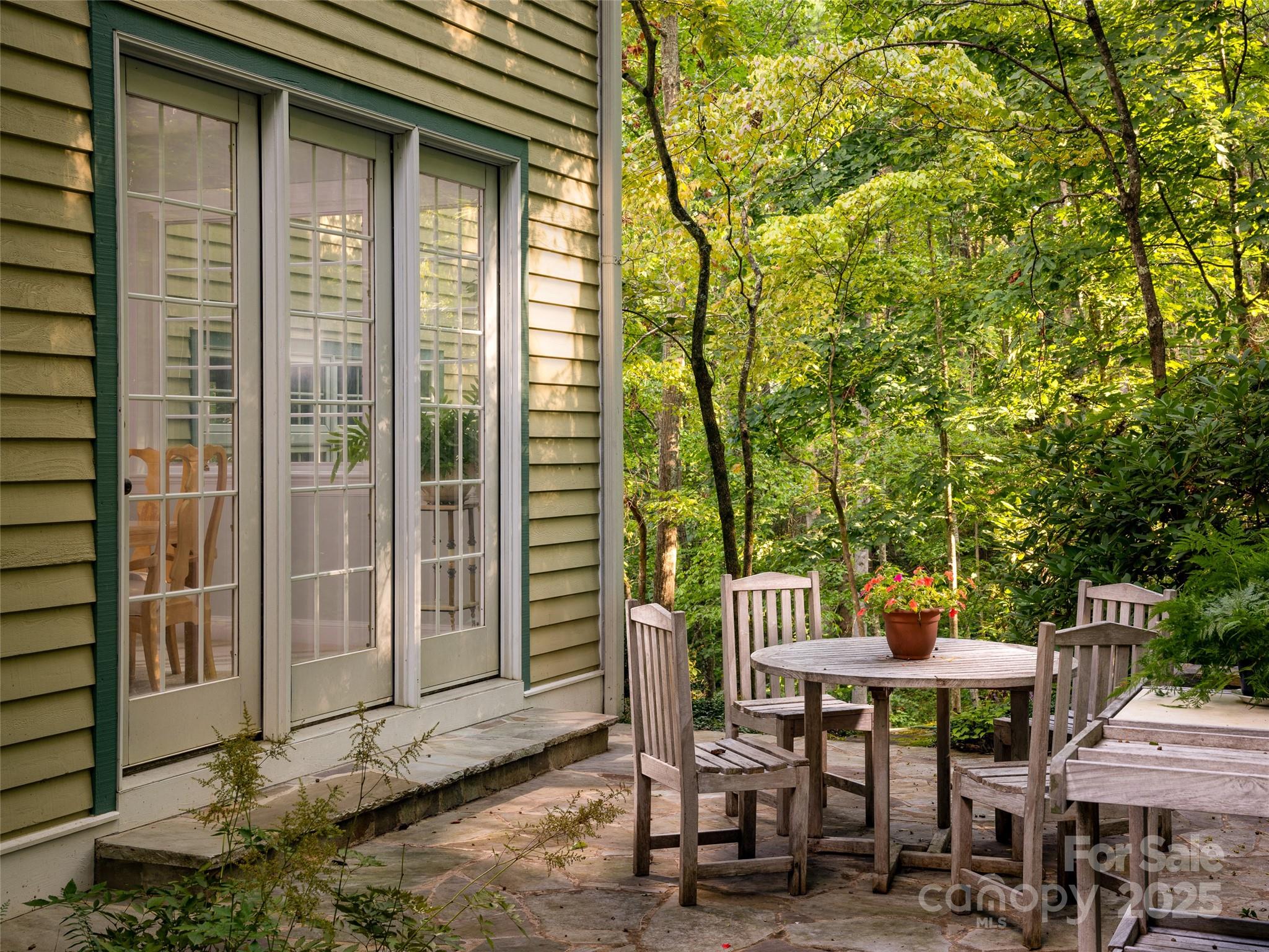 52 Robinhood Road Asheville, NC 28804 - Photo 17 of 19 a view of a patio with table and chairs and floor to ceiling window