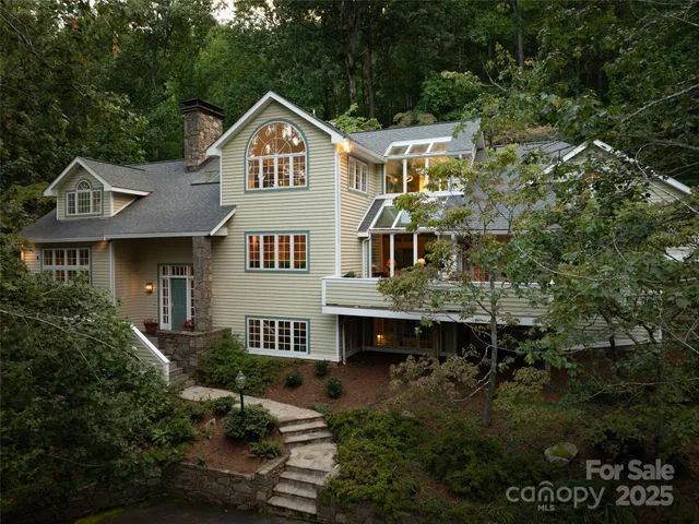 a front view of a house with a yard and potted plants