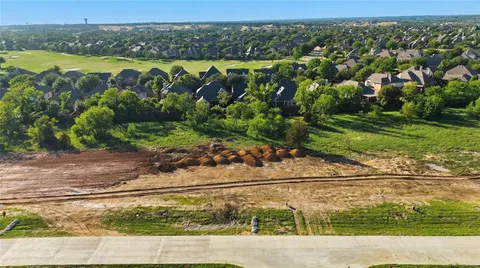 an aerial view of a house with a yard and lake view