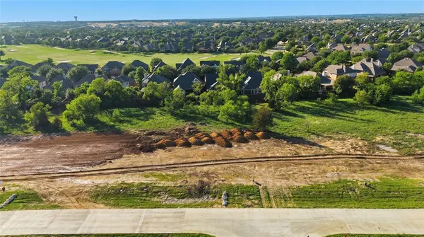 an aerial view of a house with a yard and lake view