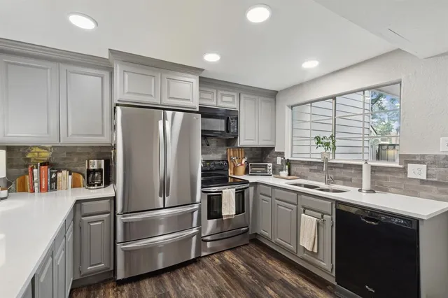 a kitchen with a sink stainless steel appliances and window