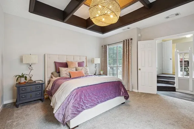 a spacious bedroom with a bed and a chandelier