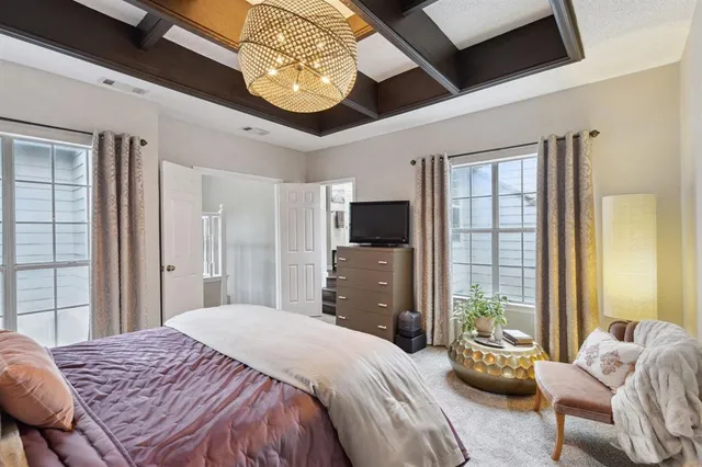 a bedroom with a bed chandelier and a window