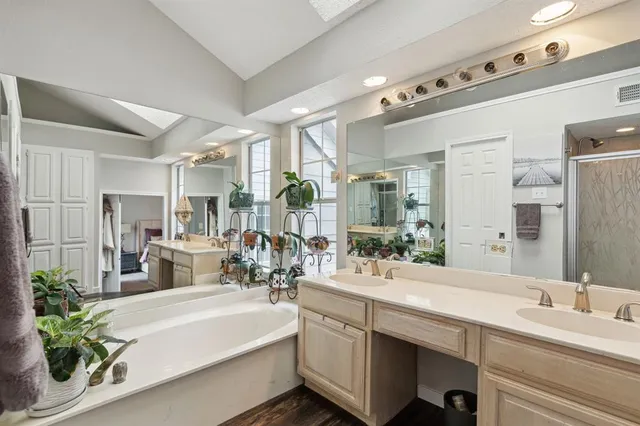 a bathroom with a double vanity sink a mirror and a bathtub