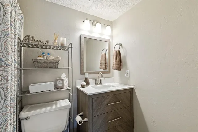 a bathroom with a sink vanity mirror and toilet